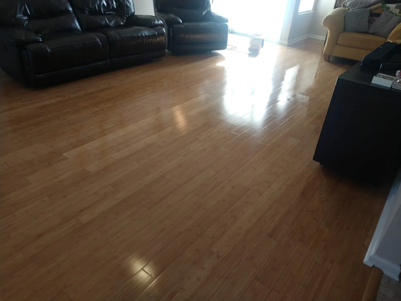 A bamboo floor in a living room with leather sofas, clean and shining.