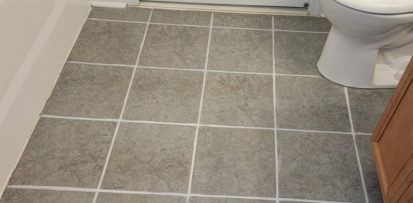 After: the same floor with bright white grout outlining every tile.