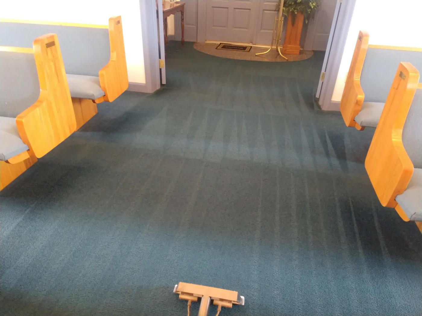A church carpet between rows of pews after cleaning.