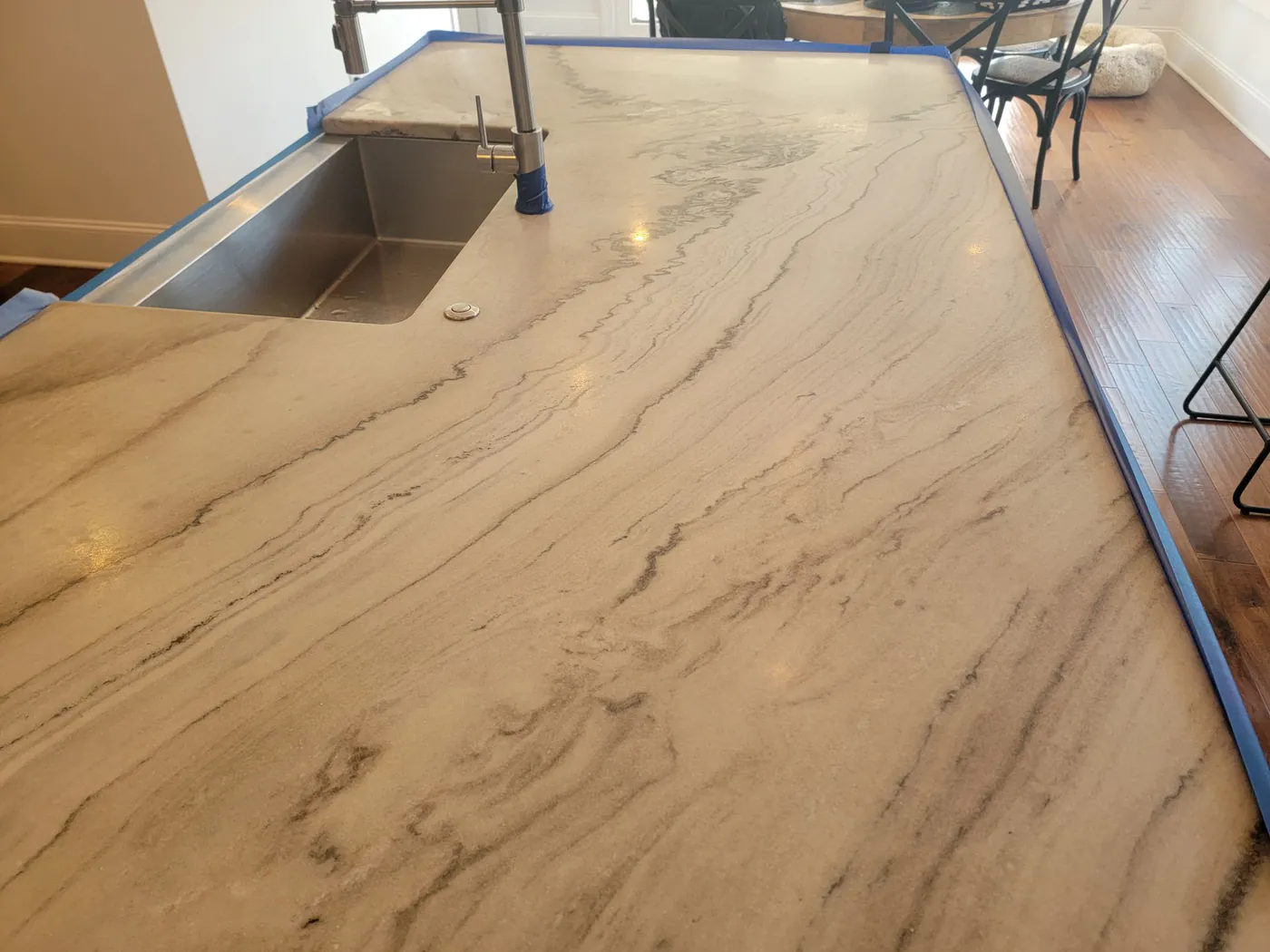 A stone kitchen island taped off with blue tape during restoration.