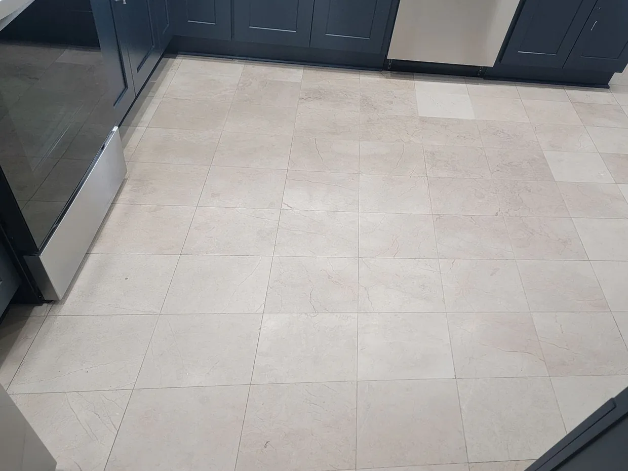 Before: a beige stone kitchen floor, flat and dull, with no reflections.