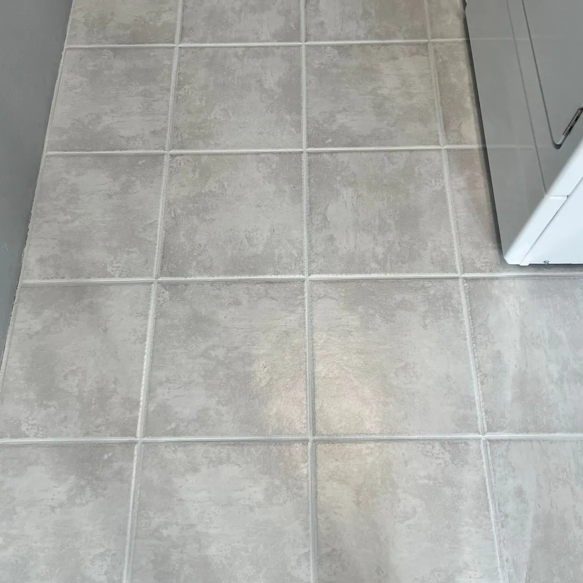 After: the same tiles with the grout lines clean and white again.