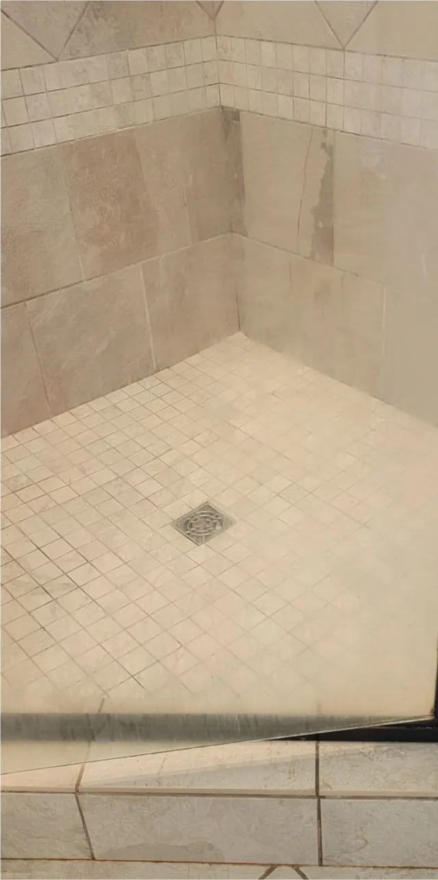 Before: a white tile shower corner with dirty grout.