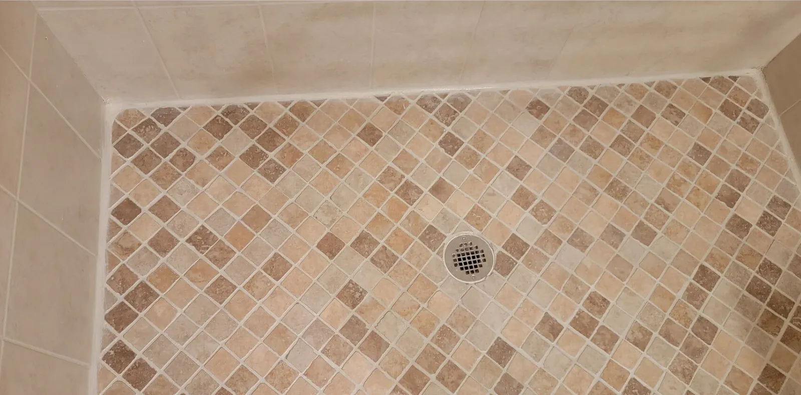 After: the same shower floor with clean, even grout and bright edges.