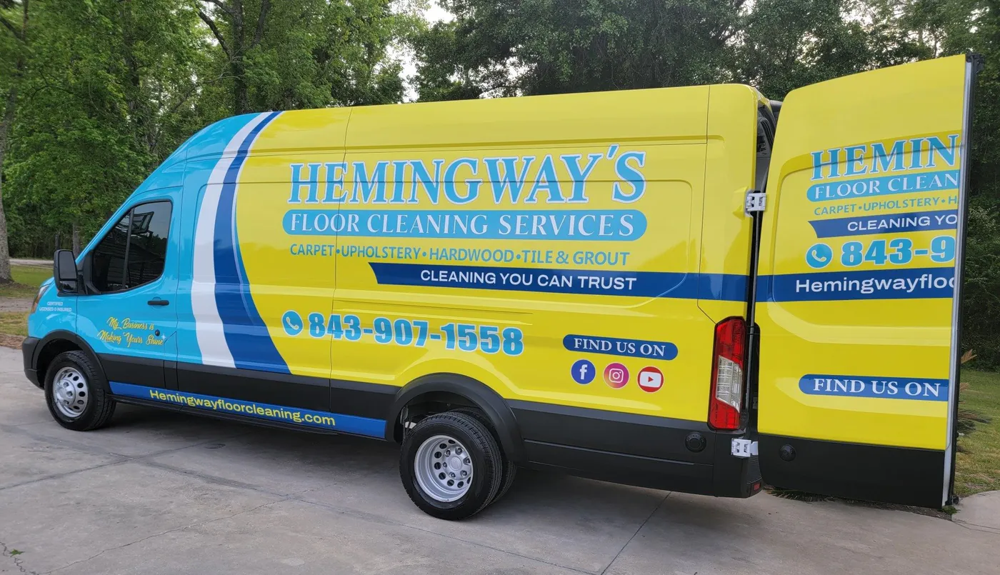 The Hemingway's van, wrapped in blue and yellow with the company name and phone number.